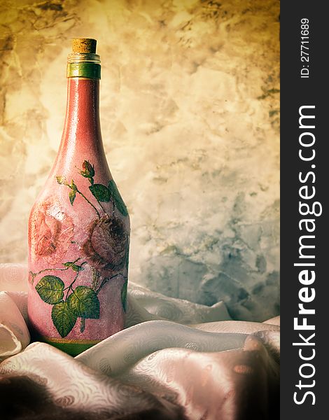 Decoupage and bottle on antique background