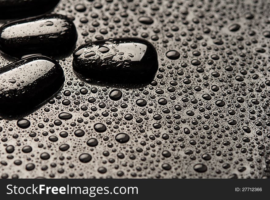Black stones and pebbles with water drops