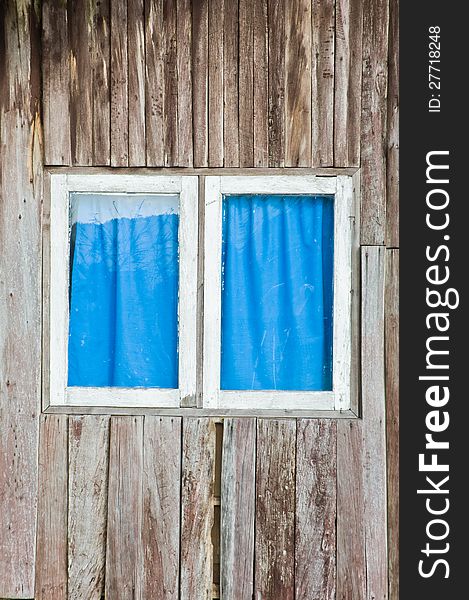 A window that have white frame and blue curtain