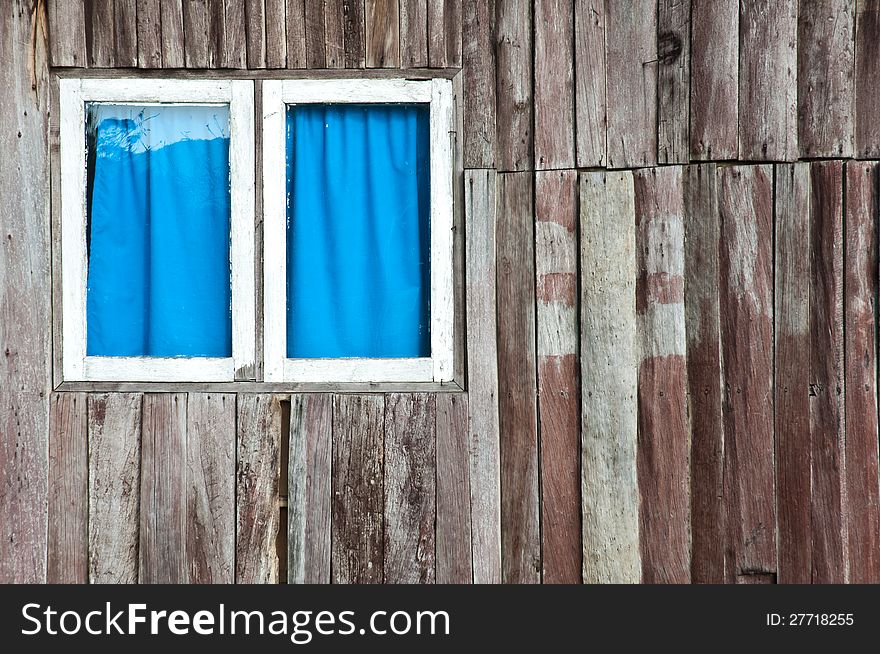 A window that have white frame and blue curtain