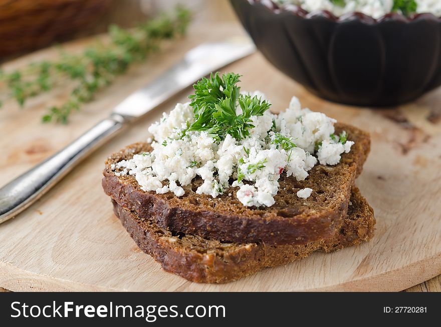 Cottage cheese pate with herbs and chili peppers on a piece of corn bread on a wooden board closeup horizontal. Cottage cheese pate with herbs and chili peppers on a piece of corn bread on a wooden board closeup horizontal