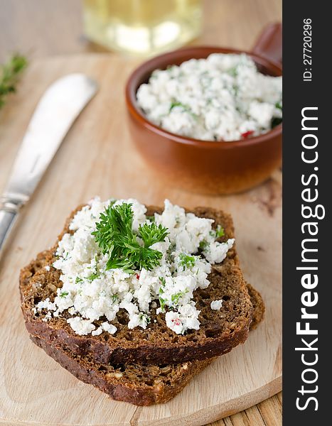 Cottage cheese pate with herbs and chili peppers on a piece of corn bread on a wooden board. Cottage cheese pate with herbs and chili peppers on a piece of corn bread on a wooden board