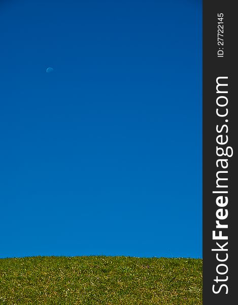 Green grass, blue sky and moon in summer day. Green grass, blue sky and moon in summer day