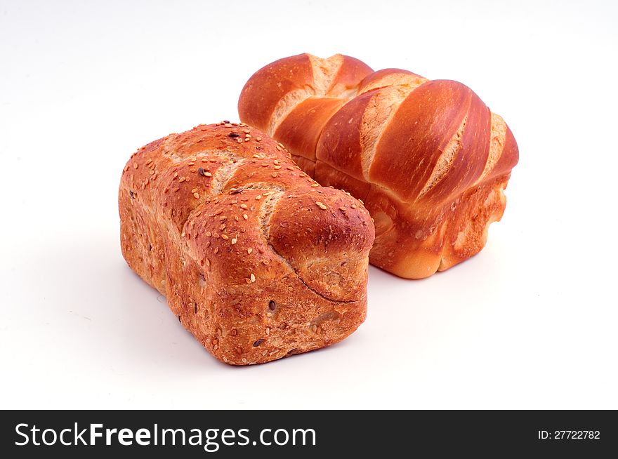 Two rolls of white and dark bread lie against a white background. Two rolls of white and dark bread lie against a white background