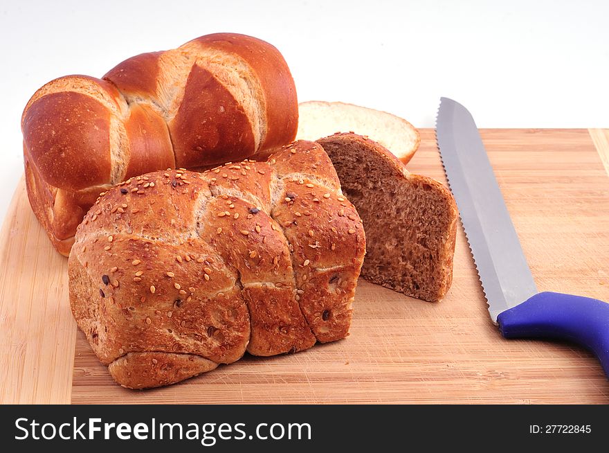 Two Loaves Of Bread And A Knife On A Board