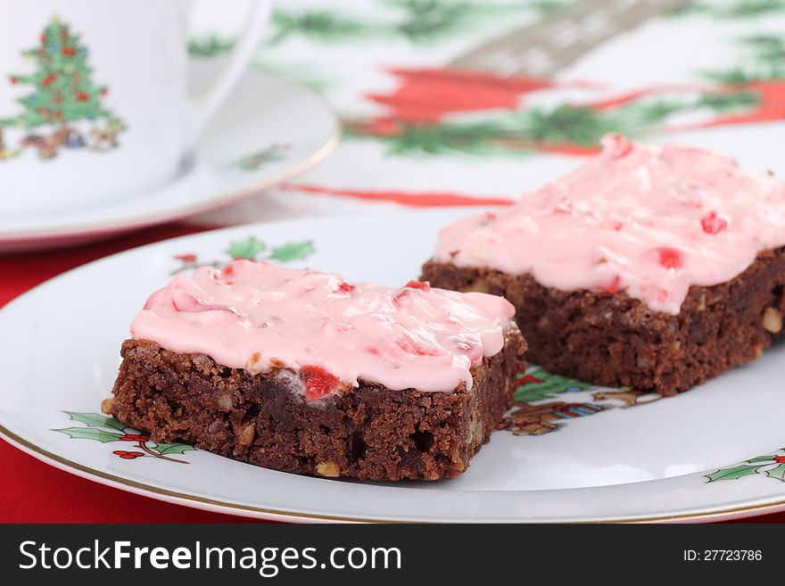 Two Christmas brownies with cherry icing on a plate