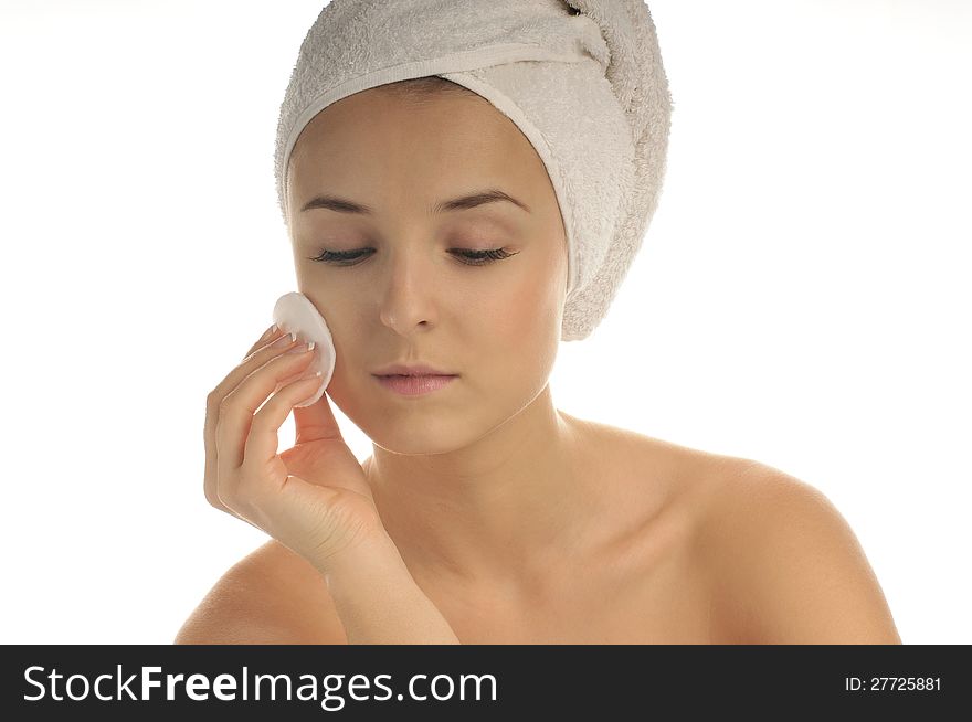 Close-up portrait of young beautiful woman with cotton swab cleaning her face