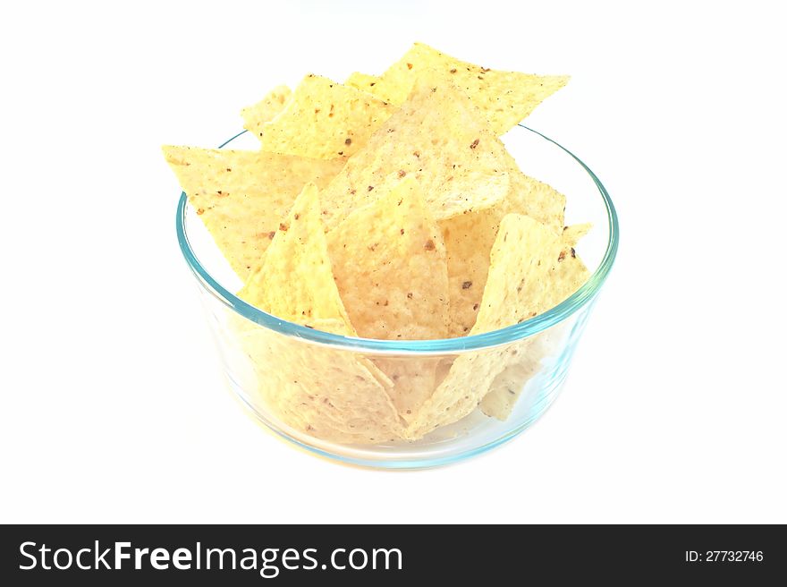 Corn tortilla chips in glass bowl isolated on white. Corn tortilla chips in glass bowl isolated on white