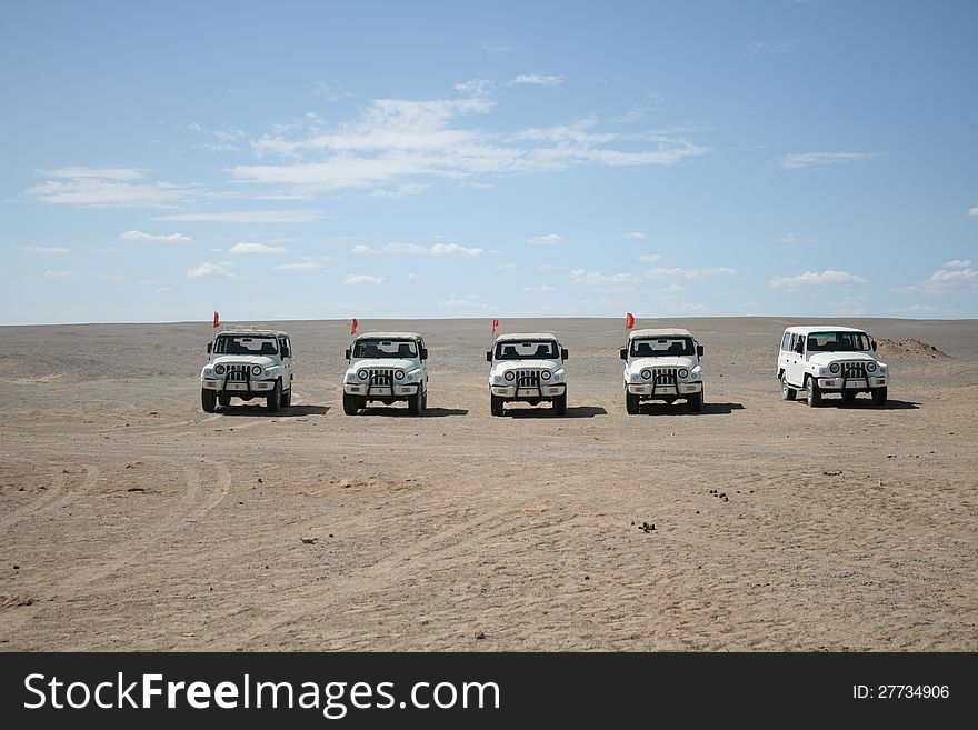 Caravan of white jeeps in the Gobi desert, Dunhuang China