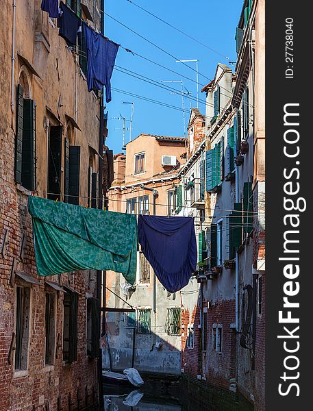 Clothes hanging out to dry between the buildings over a small canal in Venice,Italy. Clothes hanging out to dry between the buildings over a small canal in Venice,Italy.