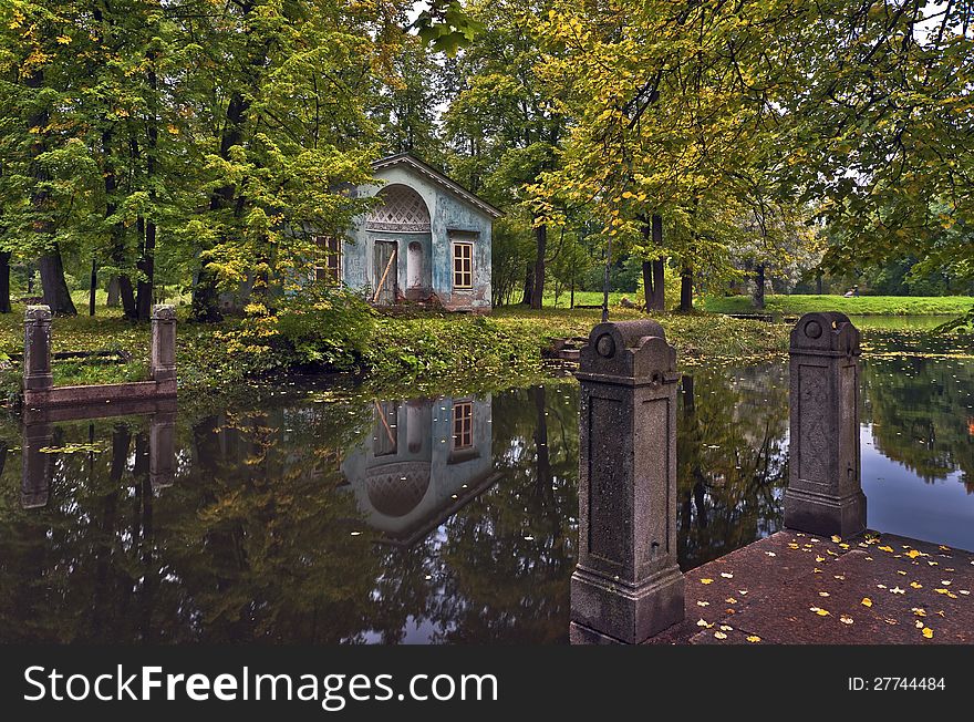 Classical pavilion next to water in the autumn park