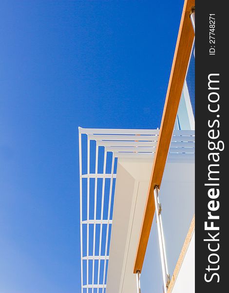 Modern style villa with louvers, handrail against blue sky background. Modern style villa with louvers, handrail against blue sky background