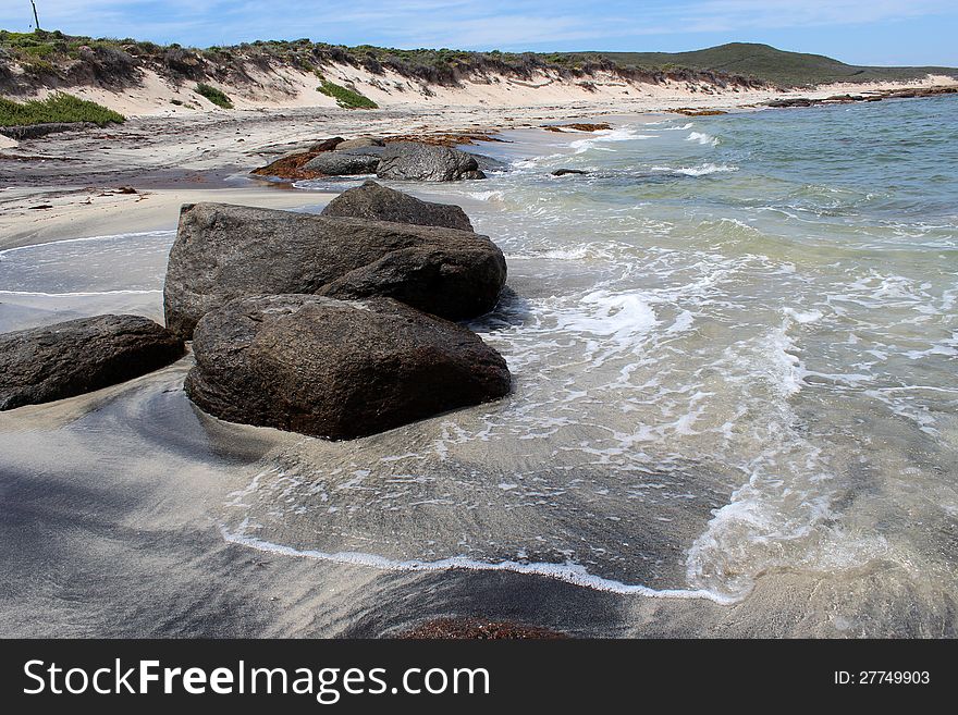 The rocky beach at Augusta Western Australia where the deep blue  Southern Ocean laps the pure white sand overlaid with mineral deposits  is a favourite fishing location.