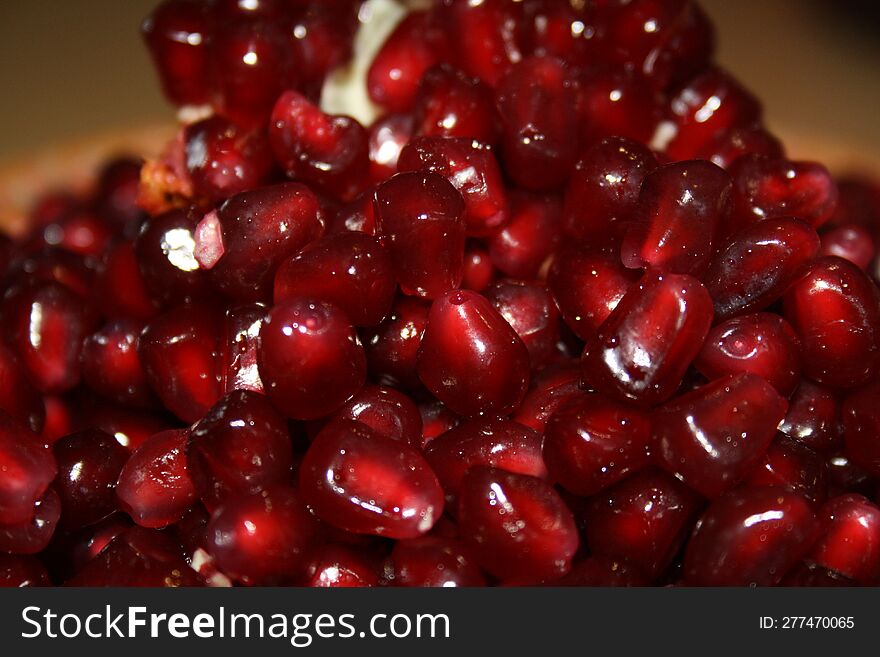 Peeled pomegranate seeds are laid out in a bowl in the of a pyramid.