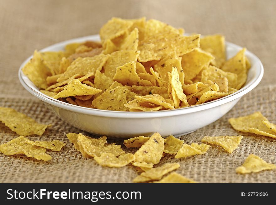 Nachos snack in the bowl on the burlap background. Nachos snack in the bowl on the burlap background