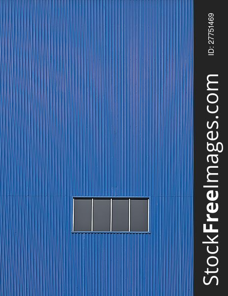 Factory window on blue wall. An industrial abstract