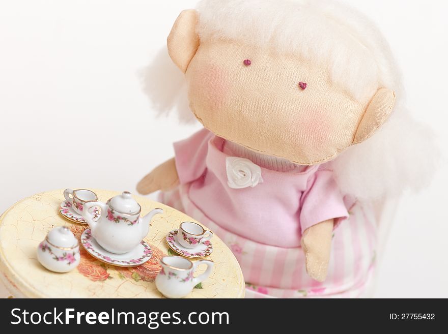 Handmade toy cute litlle girl having a tea. Handmade toy cute litlle girl having a tea