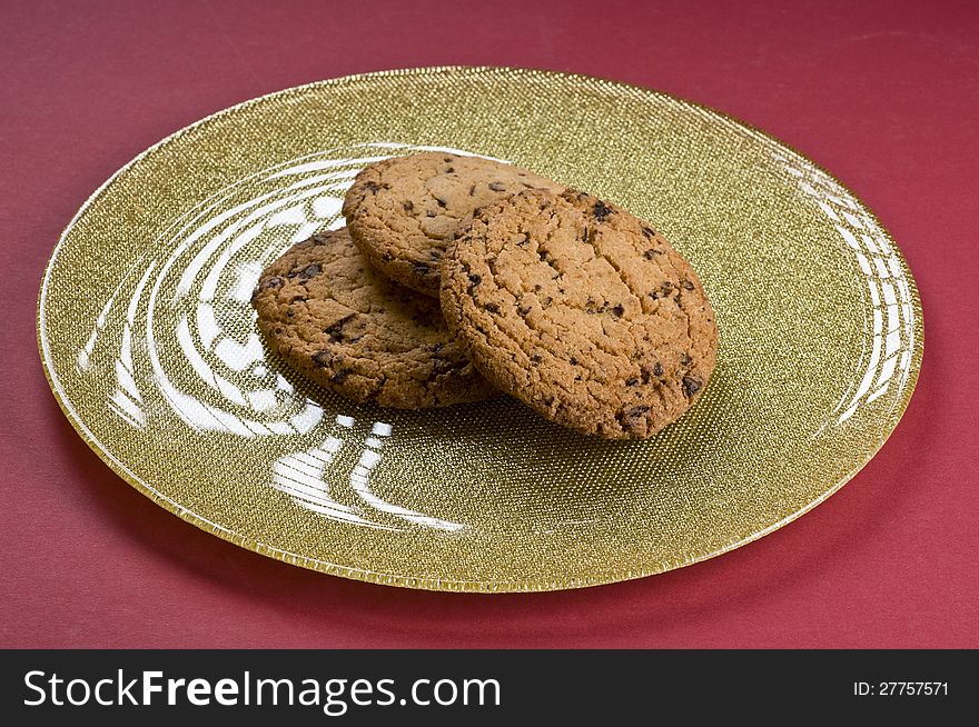 Chocolate cookies on a plate over color background