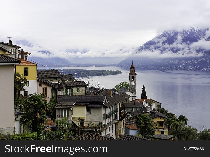 After a night of heavy rainfall the clouds begin to clear up at Ronco sopra Ascona in the Ticino canton of Switzerland.The band of whitish clouds that can be seen next to the mountains will soon dissolve. After a night of heavy rainfall the clouds begin to clear up at Ronco sopra Ascona in the Ticino canton of Switzerland.The band of whitish clouds that can be seen next to the mountains will soon dissolve.