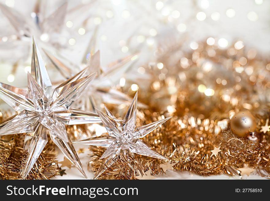 Christmas background with stars of glass on golden ribbons and defocused lights. Christmas background with stars of glass on golden ribbons and defocused lights