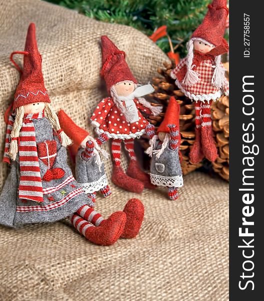 Two christmas rag dolls sitting and standing on an burlap background. Two christmas rag dolls sitting and standing on an burlap background