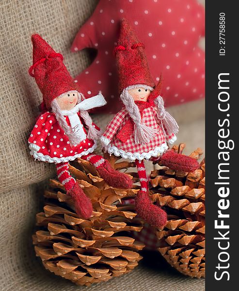 Two christmas rag dolls sitting on fir cones