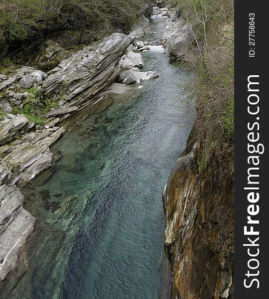 View of the Verzasca River from an old bridge in the Verzasca Valley in the Ticino area of Switzerland. Verzasca means green water and this is really true for that turqouise stream.