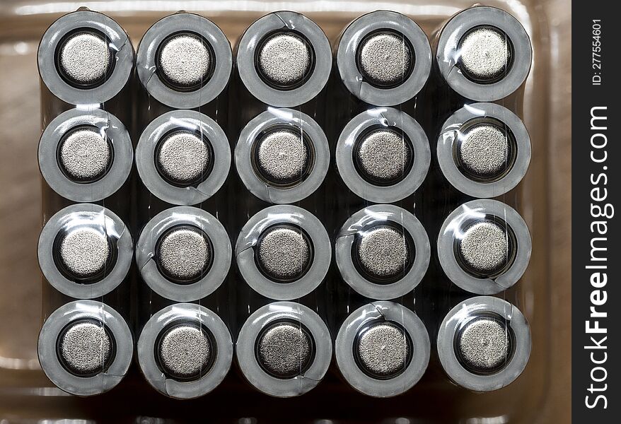 Galvanic cells, batteries are arranged in rows in the package. View from above. Background with batteries for shop, industry, busi