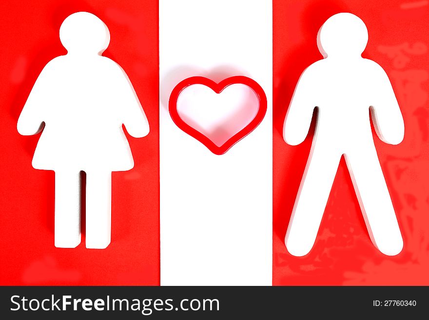 Wooden male and female figure with red heart between them. Wooden male and female figure with red heart between them