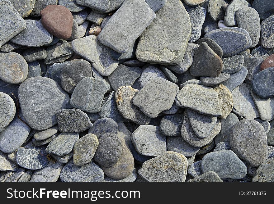 Coastal water-polished pebbles as background