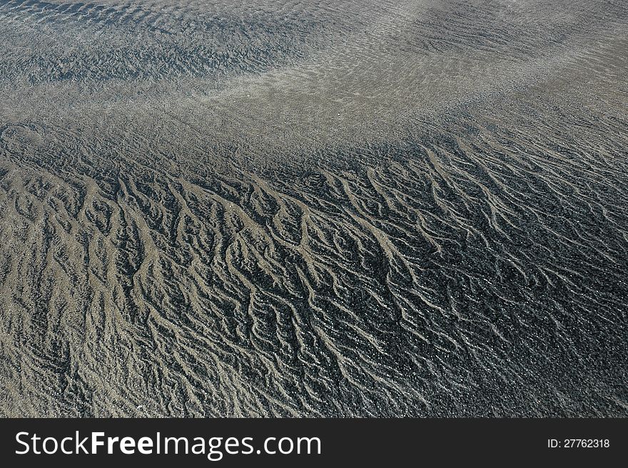 Abstract patterned background with black and gray sand of coastal India. Abstract patterned background with black and gray sand of coastal India