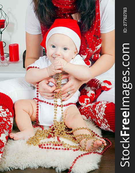 Mother holding her little son, it is Christmas time, the boy wearing Santa's hat. Mother holding her little son, it is Christmas time, the boy wearing Santa's hat