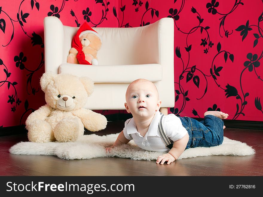 Little boy in jeans lying on a carpet with his toys. Little boy in jeans lying on a carpet with his toys