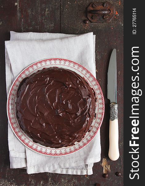 Chocolate cake with chocolate glaze on plate with a knife