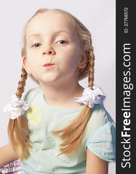 Portrait of a little caucasian fashionable girl with decorative cosmetics indoors