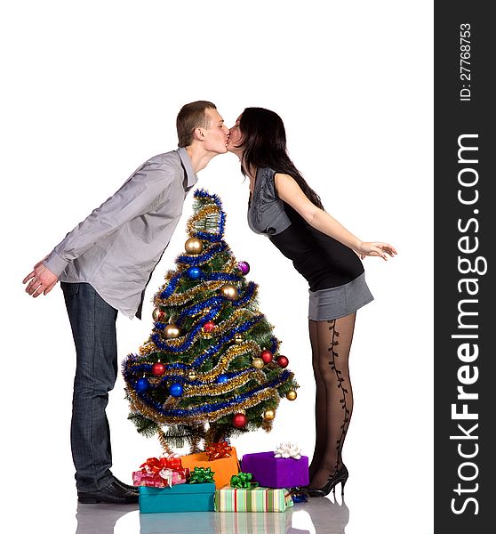 Men and women kisses over Christmas tree