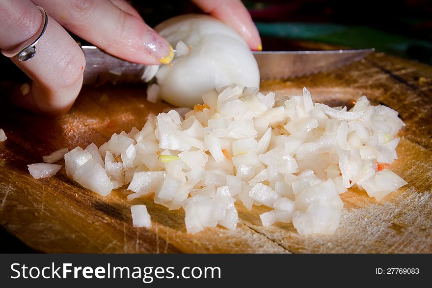 Women chopping an onion with knife. Women chopping an onion with knife