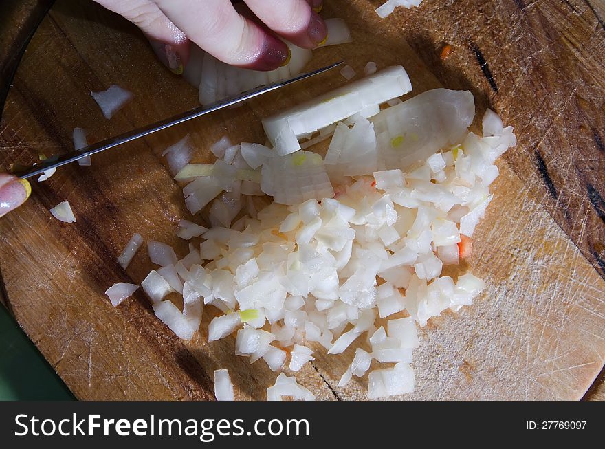 Women chopping an onion whit the knife. Women chopping an onion whit the knife