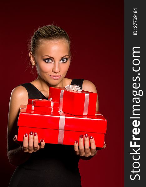 Girl in a black dress with gifts in hands