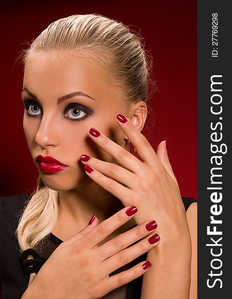 Sexy girl with aggressive makeup on a dark red background