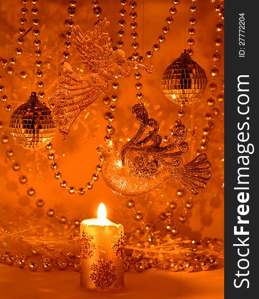 The angel, bird, beads and balls in the light of the candle. The angel, bird, beads and balls in the light of the candle
