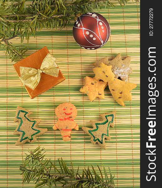 Christmas cookies with the gift and the red ball on the green stripped background. Christmas cookies with the gift and the red ball on the green stripped background