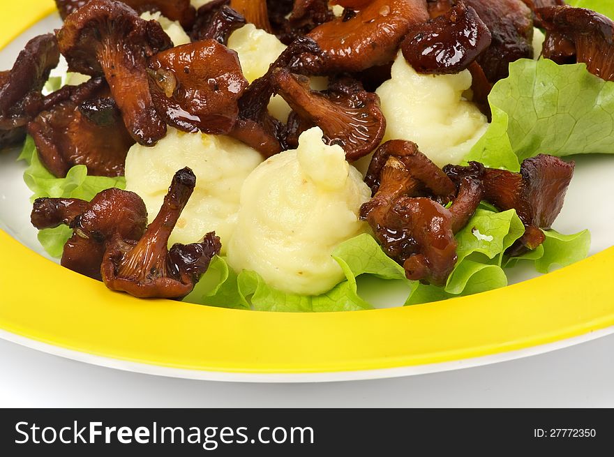 Roasted Chanterelles with Mashed Potato and Lettuce closeup on Yellow Plate