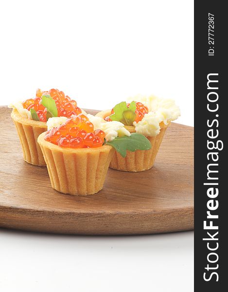 Tartlets with Perfect Red Caviar, Greens and Butter on Wooden Plate closeup. Tartlets with Perfect Red Caviar, Greens and Butter on Wooden Plate closeup