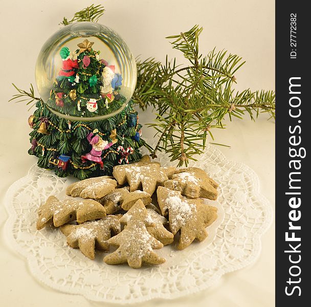 Christmas cookies with the magic ball and the conifer branch on the white napkin. Christmas cookies with the magic ball and the conifer branch on the white napkin