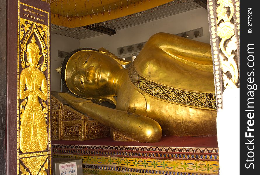 The Big golden Reclining Buddha in the important temple in Phrae, Thailand.