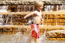 Young Boy Playing In Water Fountain Stock Images