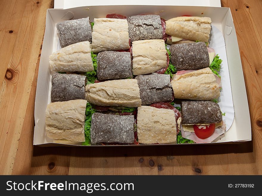 Brown and white bread roll sandwiches in a cardboard box. Brown and white bread roll sandwiches in a cardboard box