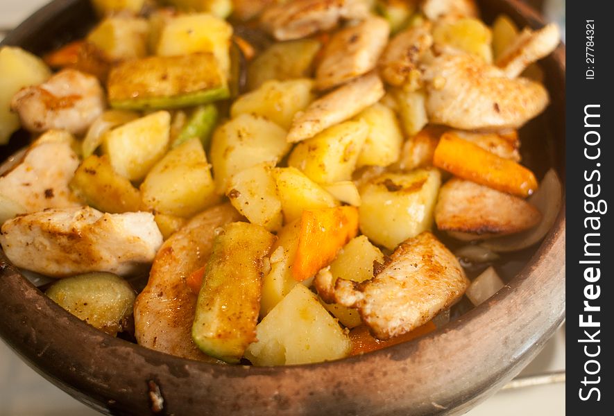 A dish made of potatoes, meat and vegetables cooked on a clay plate. A dish made of potatoes, meat and vegetables cooked on a clay plate