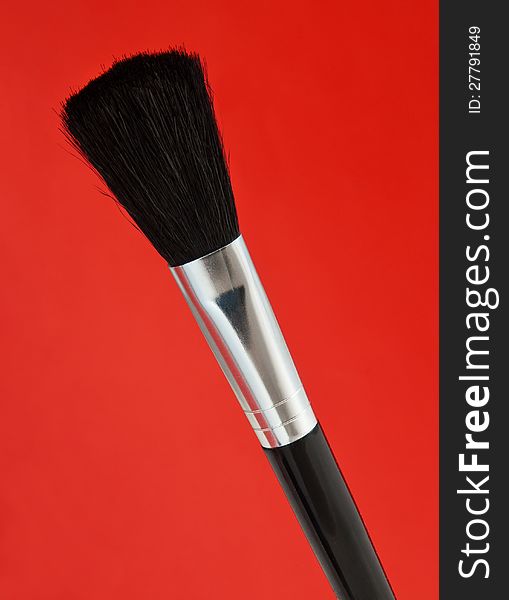 Big base make-up brush on red background. Big base make-up brush on red background